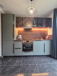 uma cozinha com armários brancos e um forno com placa de fogão em petite maison chaleureuse du GR34 em Lampaul-Plouarzel