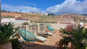 a patio with three chairs and a table on a patio at Dar Hayati in Fez