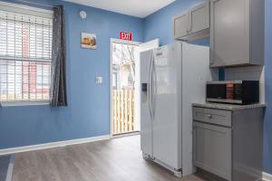 a kitchen with blue walls and a white refrigerator at Fabian's Place in Baltimore