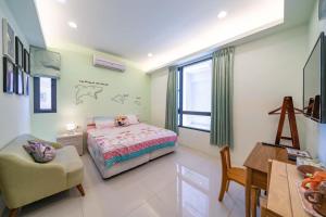una camera da letto con un letto, una sedia e un tavolo di 享樂民宿 可包棟 a Ji'an
