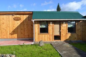 ケメロヴォにあるMini-hotel Gvardeiskayaの緑の屋根の木造キャビン