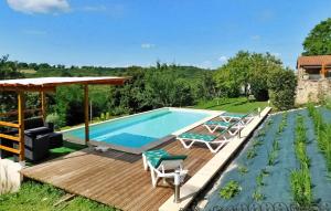 einen Pool mit einer Holzterrasse und Stühlen neben einem Haus in der Unterkunft Le Foual in Sarlat-la-Canéda