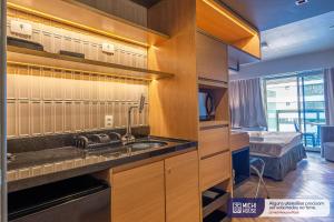 una cocina con fregadero y una cama en una habitación en MH 10001 - Aconchegante Studio com AC/WF/King en São Paulo