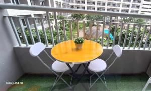 a table and chairs on a balcony with a potted plant at Snuggle and Comfy 1BR with WiFi in Grace Residences Taguig City in Manila