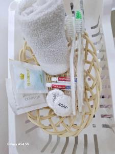 a basket filled with toothbrushes and books on a table at Snuggle and Comfy 1BR with WiFi in Grace Residences Taguig City in Manila