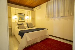 1 dormitorio con 1 cama con 2 almohadas en Regina Apartments, en Morro de São Paulo