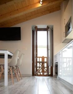 een woonkamer met een tafel en stoelen en een televisie bij Apartamentos Aldagaia in Hernani