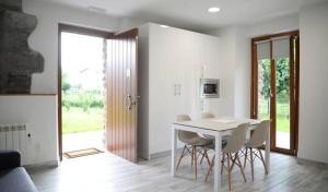 a white dining room with a table and chairs at Apartamentos Aldagaia in Hernani
