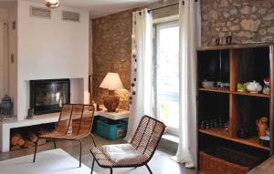 sala de estar con 2 sillas y chimenea en Arpege, en Vinezac