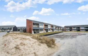 a largeartment building with a sand hill in front of it at Beautiful Apartment In Fan With House A Panoramic View in Fanø