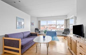 a living room with a purple couch and a table at Beautiful Apartment In Fan With House A Panoramic View in Fanø