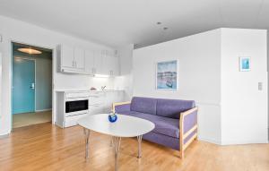 ein Wohnzimmer mit einem lila Sofa und einem Tisch in der Unterkunft Beautiful Apartment In Fan With House A Panoramic View in Fanø