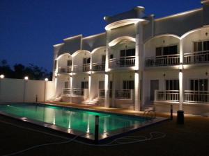un gran edificio blanco con piscina por la noche en shillahotel and resort en Ángeles