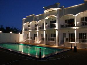 a large white building with a swimming pool at night at shillahotel and resort in Angeles