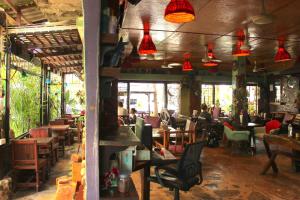 a restaurant with tables and chairs and red lights at Shanti Lodge Bangkok in Bangkok