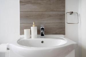 een badkamer met een witte wastafel en een spiegel bij Cosy Leith Escape - Edinburgh City in Edinburgh