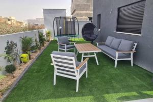 a patio with chairs and a table on the grass at Luxurious Villa at the country side! in Tel Aviv
