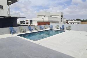 a patio with chairs and a swimming pool on a building at Luxurious Villa at the country side! in Tel Aviv