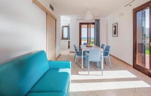 ein Wohnzimmer mit einem blauen Sofa und einem Tisch und Stühlen in der Unterkunft 2 Bedroom Beach Front Home In Marina Di Modica in Marina di Modica