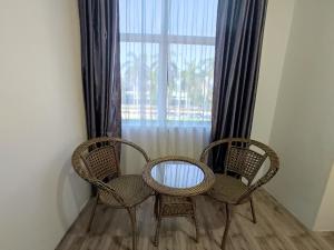 two chairs and a table in front of a window at Tambun Warm Hotel in Ipoh