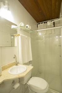 y baño con aseo, lavabo y ducha. en Regina Apartments, en Morro de São Paulo