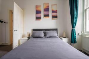 een slaapkamer met een groot bed met blauwe lakens bij Cosy Leith Escape - Edinburgh City in Edinburgh