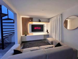 uma sala de estar com um sofá e uma televisão em Linda casa de 2 pisos, con cochera cerca de PIMENTEL em Chiclayo
