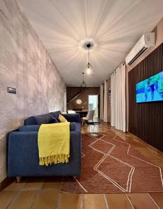 uma sala de estar com um sofá azul e uma televisão em Cozy Up Spain em Valência
