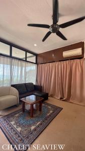 a living room with a couch and a ceiling fan at Lovita Tanjung Bidara Beach Resort in Malacca