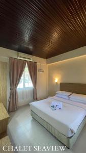 a bedroom with two beds and a wooden ceiling at Lovita Tanjung Bidara Beach Resort in Melaka