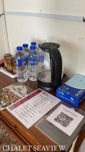 una cafetera y botellas de agua en una mesa en Lovita Tanjung Bidara Beach Resort, en Melaka