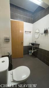 a bathroom with a toilet and a sink and a mirror at Lovita Tanjung Bidara Beach Resort in Melaka