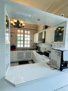 a kitchen with white cabinets and a white counter top at Green Villa Grandeur at A Famosa Resort Melaka in Kampong Alor Gajah