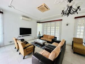 a living room with a couch and a television at Green Villa Grandeur at A Famosa Resort Melaka in Kampong Alor Gajah
