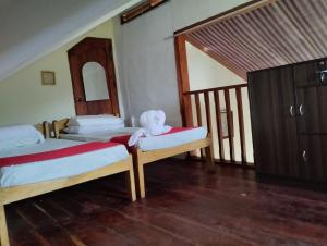 a bedroom with two beds with a teddy bear sitting on them at Bliss Accommodation in Malaybalay