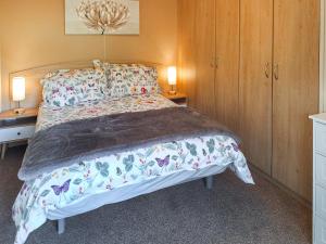 a bedroom with a bed and two lamps on two tables at Glen Y Nant in Llanfihangel-nant-Melan