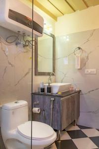 a bathroom with a toilet and a sink at Jais Cottage A Charming Hideaway in Shimla