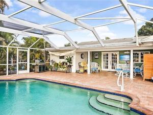 a house with a swimming pool with a pergola at 7 Palms Pool House in Cape Coral