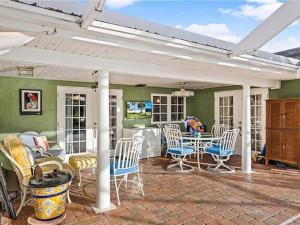 a covered patio with a table and chairs at 7 Palms Pool House in Cape Coral