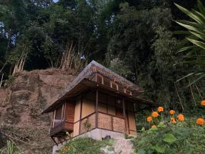 a small house on a hill with orange flowers at Art Mile Kalimpong in Kalimpong