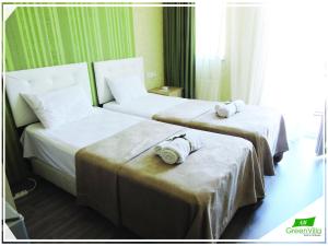 two beds in a hotel room with towels on them at Green Villa in Batumi