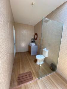 a bathroom with a toilet and a glass shower at The Jangkar Canggu Guesthouse & Villa in Canggu