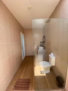 La salle de bains est pourvue de toilettes et d'une paroi en verre. dans l'établissement The Jangkar Canggu Guesthouse & Villa, à Canggu