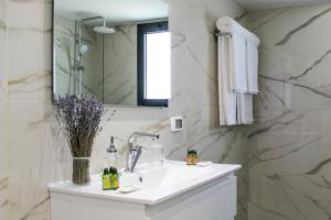 a white bathroom with a sink and a mirror at Luxury Penthouse #46 By Hashdera Eilat in Eilat