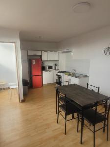 a kitchen with a table and chairs and a red refrigerator at C&C TALTAL in Taltal
