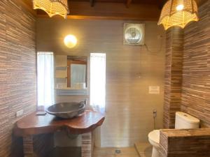 a bathroom with a bowl sink on a wooden counter at Casa Nemo Beach Resort & Spa in Sabong