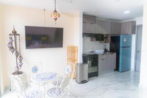 una cucina con tavolo, sedie e frigorifero di Apartamento en Panamá Céntrico y lujoso en Panamá de la zona Bancaria a Città di Panama