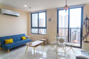 uma sala de estar com um sofá azul e janelas grandes em Apartamento en Panamá Céntrico y lujoso en Panamá de la zona Bancaria em Cidade do Panamá