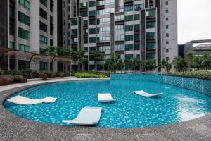 a swimming pool with two lounge chairs in a building at Cubic Botanical Chill Massage Chair 7km- MidValley in Kuala Lumpur