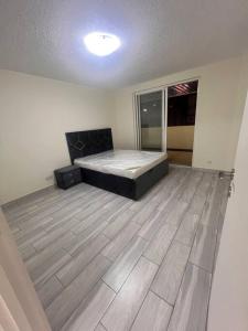 a bedroom with a bed and a wooden floor at Deira Family Rooms in Dubai